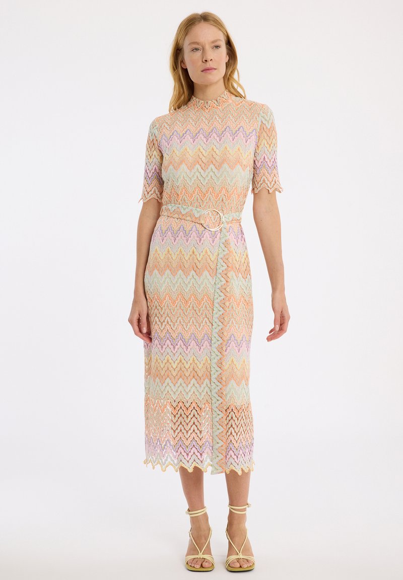 Spitzenkleid mit Chevron-Muster in Pastellfarben, hohem Kragen, kurzen Ärmeln und tailliertem Gürtel. Wellenförmiger Saum.