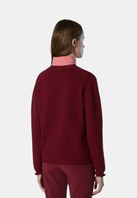 Maglione borgogna con texture a coste e colletto a righe rosa, caratterizzato da una vestibilità comoda e maniche lunghe, visto da dietro.