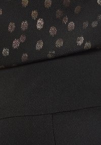 Melna auduma, kurā ir metāliski punkti dažādos izmēros. Gluda tekstūra ar elastīgu jostasvīru un šuvju trūkumu, lai nodrošinātu komfortu.