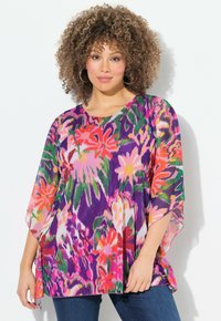 Top floreale colorato con un design sciolto e fluido. Caratterizzato da tonalità vivaci di viola, rosa e verde. Tessuto leggero con maniche ampie.