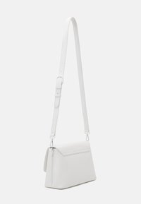 Vit läder crossbody-väska med överviktslock, justerbar rem, silverdetaljer och en slät, texturerad yta.