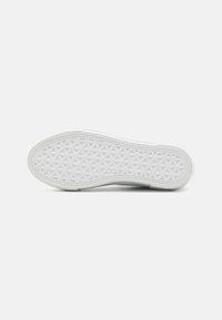 Vit sneakersula med en texturerad design som har ett geometriskt mönster. Gummimaterialet verkar hållbart med en slät yta.