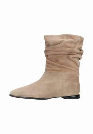 Bottine basse en daim marron clair, souple, avec un bout pointu arrondi et un petit talon noir sur fond blanc.