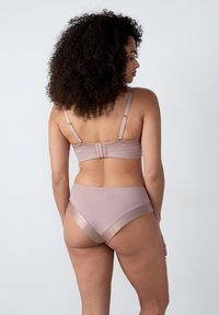 Set di reggiseno e culotte in un morbido color mauve tenue. Il reggiseno presenta spalline regolabili e chiusura a gancio; le culotte hanno dettagli in satin a contrasto e una finitura liscia.