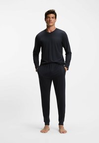 Ciemnoszary, długi rękaw, top z dekoltem w serek oraz dopasowane zwężane spodnie. Miękka faktura z elastycznym pasem. Bez wzorów, minimalistyczny design.