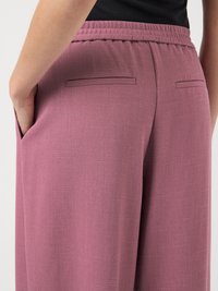 Pantalon en coton lavande tissé avec une finition texturée, doté d'une ceinture plate et de poches latérales, présenté de dos.