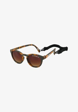 Lunettes de soleil en écaille de tortue avec des verres bruns dégradés, en forme de cat-eye incurvée, avec des montures épaisses et une sangle noire ajustable attachée.