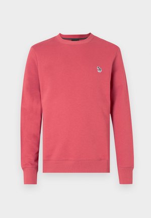 Punane puuvillane sviitriga, millel on ümmargune kaelus, pikad varrukad ja väike tikand, millel on värviline käe logo.