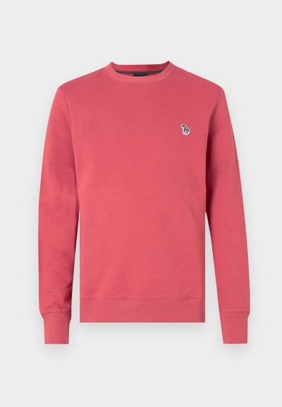 Raudona medvilninė sportinė palaidinė su apvaliu kaklu, ilgomis rankovėmis ir maža siuvinėta grafika, vaizduojančia spalvingą rankos logotipą.