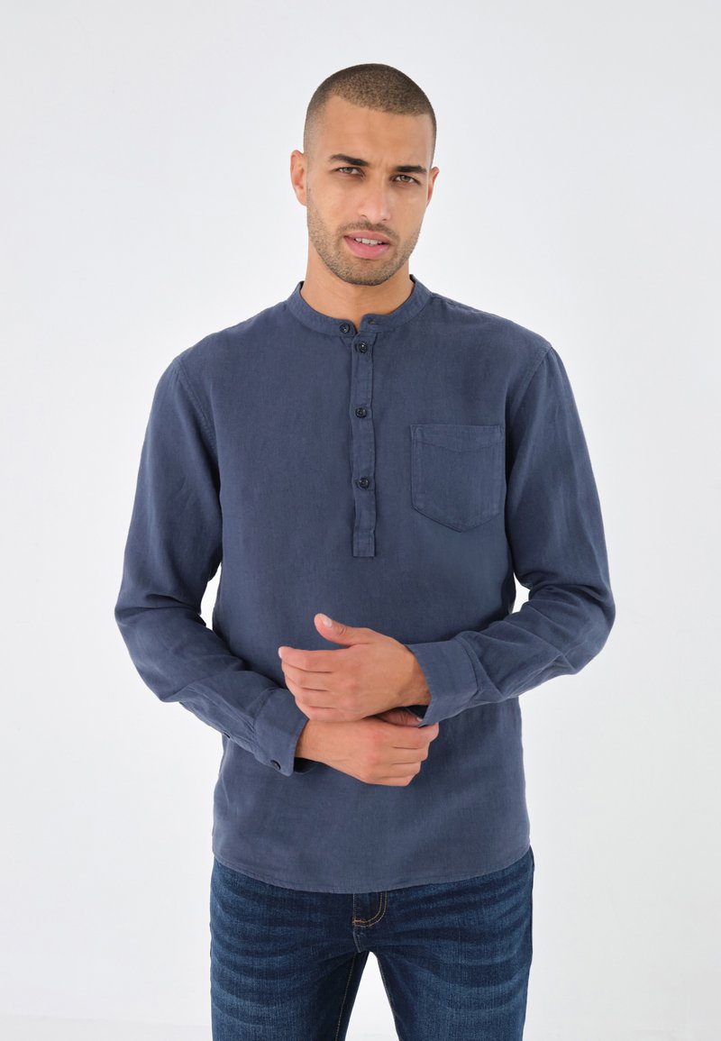 Dunkelblaues Langarmshirt mit Rundhalsausschnitt, Knopfleiste und Brusttasche. Weicher Stoff mit lässiger Passform.