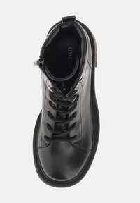 Stivale ankle in pelle nera con punta tonda, design con lacci, zip laterale e suola testurizzata per una migliore aderenza. Logo visibile all'interno.