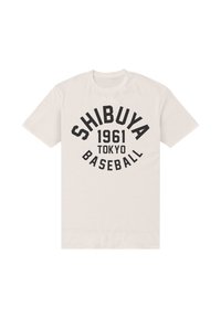 Bílé tričko s krátkým rukávem s černým nápisem "SHIBUYA 1961 TOKYO BASEBALL" v křivkovém designu na přední straně.