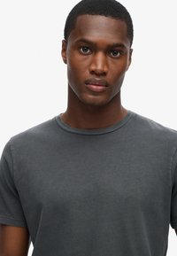 Grå bomulds T-shirt med rund halsudskæring, korte ærmer og en glat overflade. Designet til en tætsiddende silhuet.