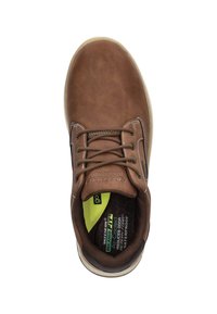 Zapato de cuero marrón con punta redonda, costuras blancas en contraste, diseño con cordones, plantilla acolchada y etiqueta interior verde que indica características impermeables.