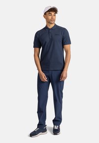 Námořnická polokošile s krátkými rukávy, hladký povrch, zapínání na knoflíky, v kombinaci s odpovídajícími námořnickými kalhotami a námořnickými teniskami s bílými akcenty.