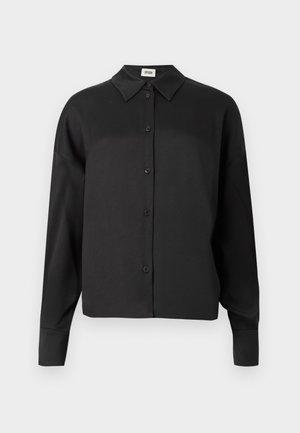 Svart langermet skjorte med krage, med en glatt tekstur og et cropped snitt. Knapper er mørke og jevnt fordelt.