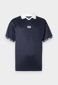 Tricou polo albastru marin cu un model de forme interconectate în formă de 'R', guler alb și mâneci contrastante cu logo-ul Reebok.