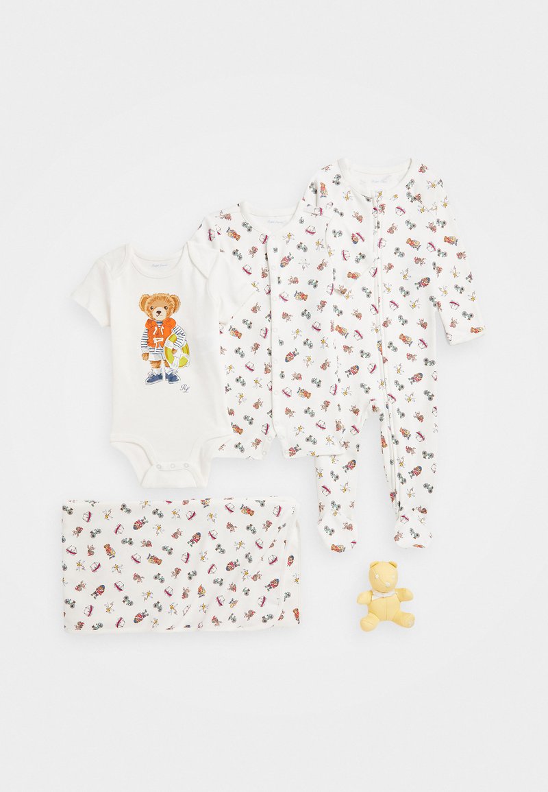 Set of baby clothes including a short-sleeve bodysuit with a bear graphic, patterned sleep suits, and a blanket featuring colorful prints.