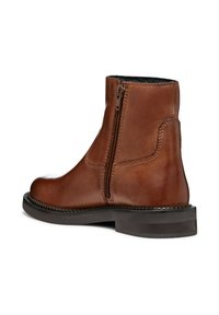 Brown leather ankle boot with a side zipper, rounded toe, and a textured sole. Features contrasting stitching and smooth finish.