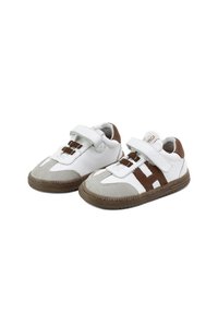 Zapatillas de cuero con parte superior blanca, acentos marrones y punteras grises. Cuentan con una correa de velcro y una suela de goma texturizada.