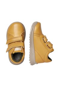 Scarpe in pelle gialla con due cinturini in Velcro regolabili, punta arrotondata, suola testurizzata e suola in gomma grigia. Interno foderato con motivo a zigzag.