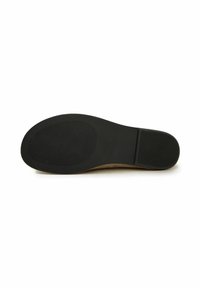 Semelle d’une chaussure habillée marron avec talon en caoutchouc noir et avant-pied texturé pour l’adhérence, vue de dessous sur fond blanc.