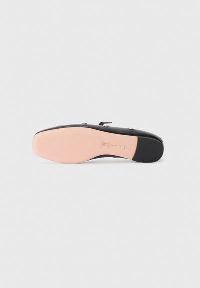 Black shoe sole with a smooth, rounded shape, featuring a light pink bottom. Includes embossed branding and a small heel design.