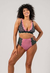 Spoonbralette och högmidjad bikiniuppsättning i rosa och gröna färger, med vågiga kanter och mjuk, slät textur.