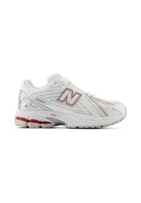 Λευκό αθλητικό παπούτσι New Balance 1906R με κόκκινες λεπτομέρειες, επάνω μέρος από δίχτυ και επενδυμένη σόλα, εμφανίζεται από το πλάι σε λευκό φόντο.