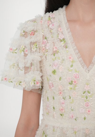 Broderad klänning med blommönster i rosa och grönt, genomskinligt tyg, volangärmar och V-ringning. Strukturerad och delikat design.