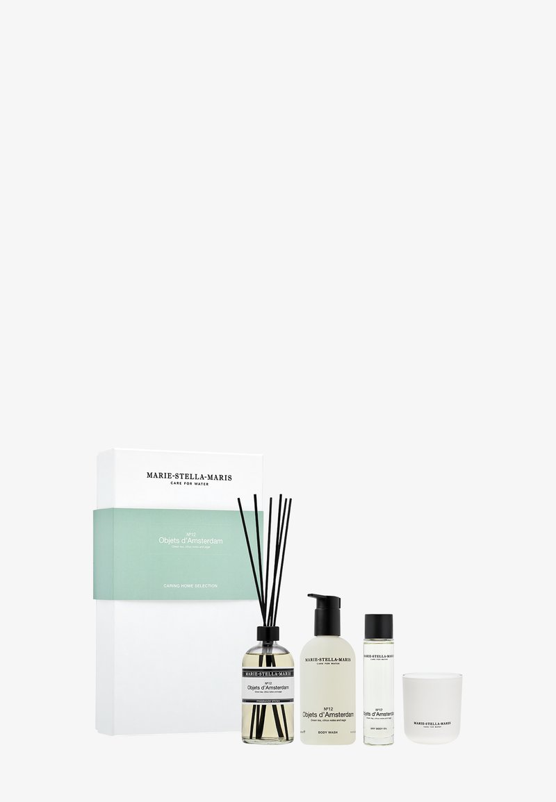 Coffret cadeau parfum d'intérieur comprenant un diffuseur à tiges, un gel douche et une bougie. Contenants en verre transparent et beige avec texte noir, présentés dans une boîte blanche.
