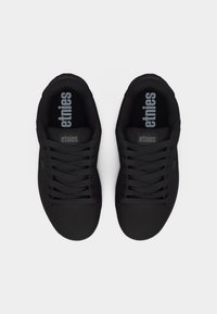 Ζεύγος μαύρων αθλητικών παπουτσιών Etnies με κορδόνια, σε άποψη από πάνω σε απλό λευκό φόντο.