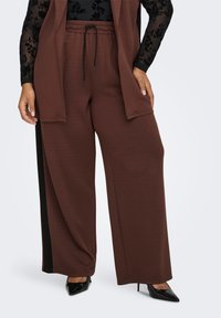 Brown wide-leg pants with a drawstring waist, featuring a side black accent stripe. The fabric appears soft with a smooth texture.