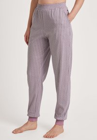 Paarse gestreepte slaapbroek met een elastische tailleband, zijzakken en aansluitende boorden. Zachte stof met een geometrisch patroon.