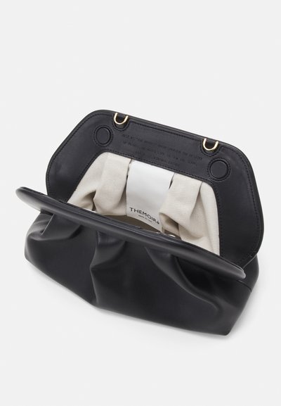 Pochette in pelle nera con interno in morbido tessuto crema e un'etichetta che recita "THEMOIRÈ" all'interno della patta aperta.