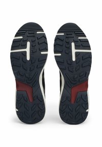 Podeszwa sneakersów wykonana z teksturowanej granatowej gumy z białą wkładką i bordowym akcentem, zaprojektowana z myślą o przyczepności i trwałości.