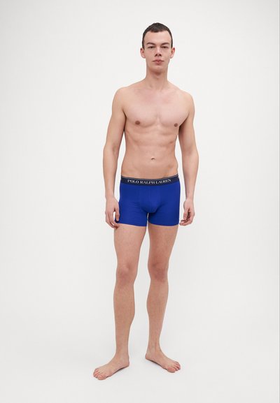 Férfi kék boxer alsónadrág sima anyagból, fekete derékkal, melyen a "POLO RALPH LAUREN" logó található. Feszes sziluettre lett tervezve.