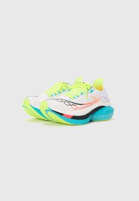 Zapatillas de running blancas con cordones amarillos vibrantes, acentos verdes neón y una suela acolchada en negro, azul y lima. Presenta una parte superior de malla y un logo.