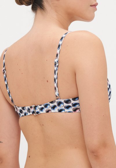 Flerfarget bikini topp med et mønster av sirkler i blått, svart og rosa. Har justerbare stropper og en spennelukking bak.