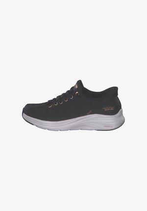 Black sneaker with a smooth upper, round toe, and prominent white midsole. Features brown eyelets and "Contour Foam" label on the side.