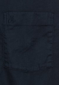 Dunkel marineblaues Hemd mit Stofftasche und dezent eingestickten Buchstaben "MOP" nahe der oberen linken Ecke der Tasche.