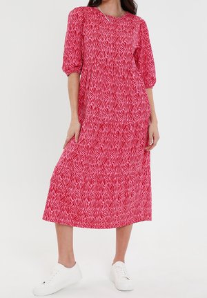 Punaiset ja vaaleanpunaiset kuviolliset midi-mekko, jossa on puffihihat, kerroksellinen muotoilu, pyöreä pääntie, yhdistettynä valkoisiin tennareihin. Puuvillamainen rakenne.