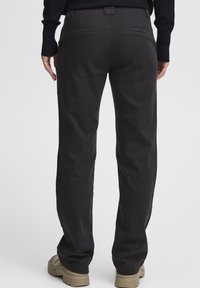 Črne hlače s ravnimi nogavicami, izdelane iz debelega, gladkega materiala. Imajo dve zadnji žep in subtilno teksturo.