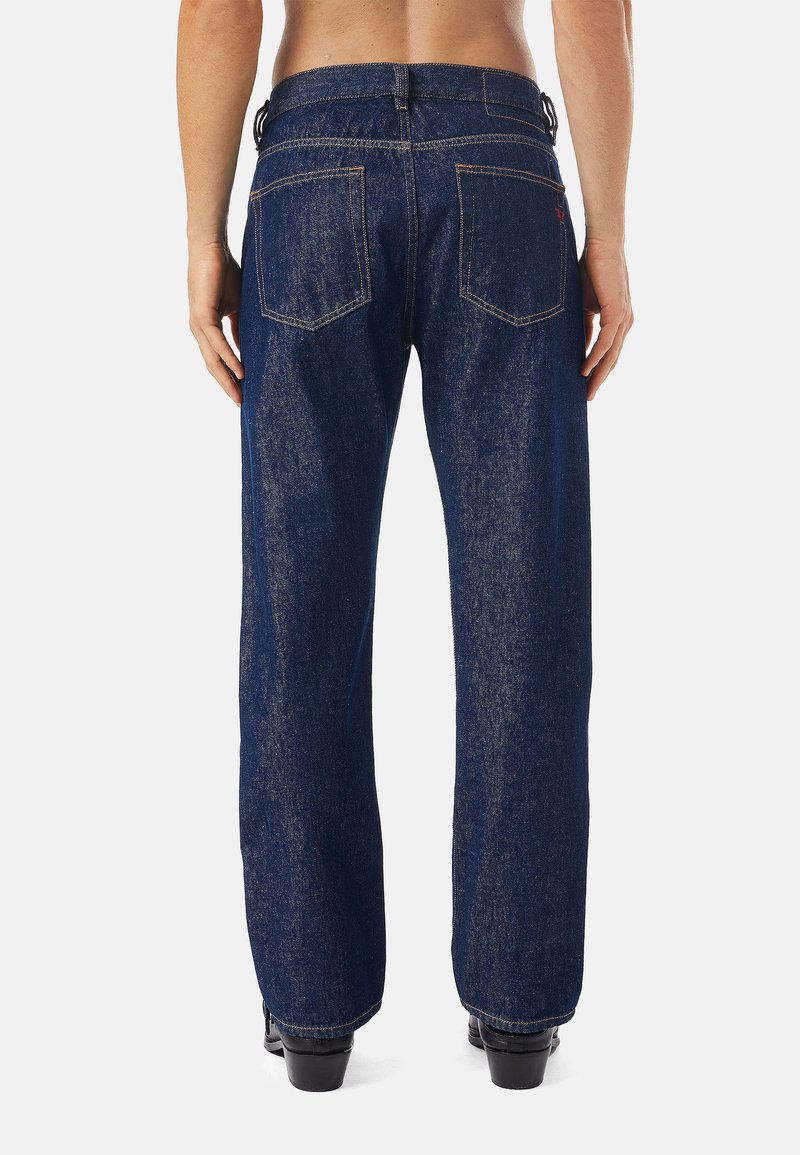 Dunkelblaue Jeans mit geradem Bein, sichtbaren Nähdetails, zwei Gesäßtaschen und einem mittelhohen Bund.