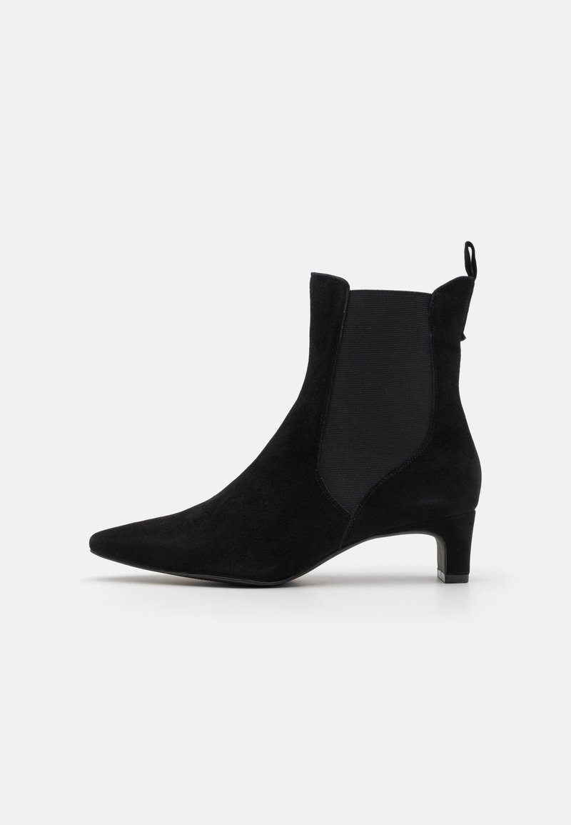 Bottine en daim noire avec bout pointu, panneau latéral élastique, languette à l’arrière et petit talon kitten.