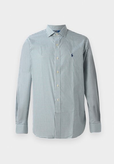 Camisa de botão em padrão xadrez gingham azul e branco, mangas longas, colarinho clássico, apresentando um pequeno emblema bordado no peito.