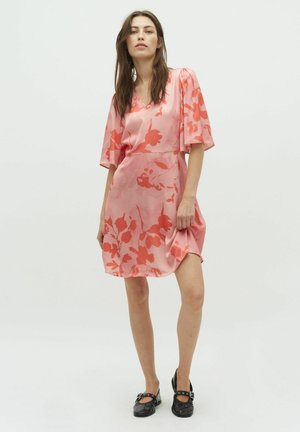 Pink satin dress with floral patterns in coral hues, featuring short puff sleeves, a V-neckline, and a relaxed fit that falls above the knee.