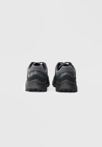 Ein Paar schwarze und graue Sportschuhe von hinten auf einem schlichten weißen Hintergrund dargestellt.