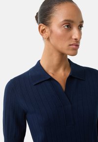 Námornicky modrý žebrovaný pletený polo svetr s límečkem a krátkými rukávy, s knoflíkovou légou a texturovaným designem.