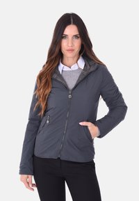 Giacca isolante grigia con chiusura a zip, cappuccio regolabile e due tasche laterali. Caratterizzata da una superficie liscia e un design leggero.